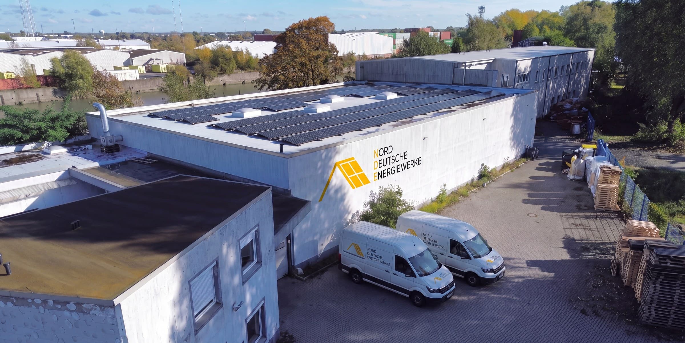 Unser Lager am Hamburger Hafen mit Solardach, Firmenschild und Transportern